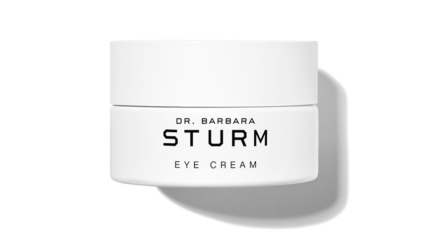 A white jar labeled Dr. Barbara Sturm Eye Cream is shown on a white background, casting a soft shadow to the right.