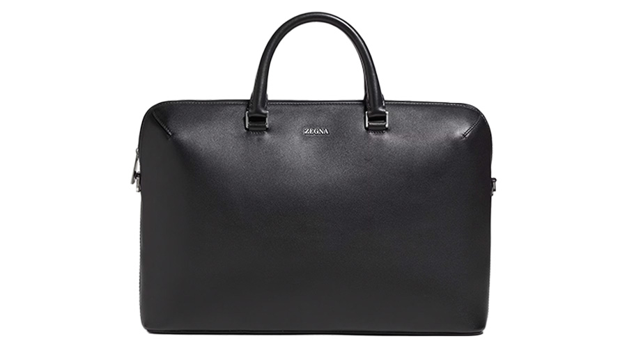 A black leather briefcase with two handles and a silver Zegna logo on the front, shown against a white background.