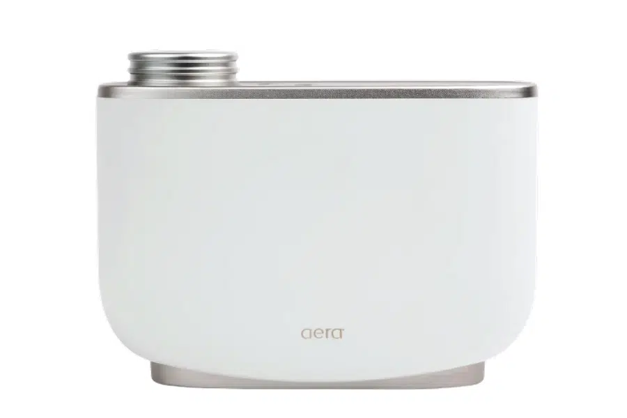 A white, modern cylindrical device with metallic accents and a screw-top opening, labeled aera at the bottom center.