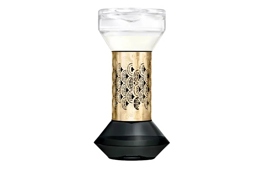 A decorative hourglass-shaped object with a transparent top, intricate gold-patterned middle, and black base, set against a white background.