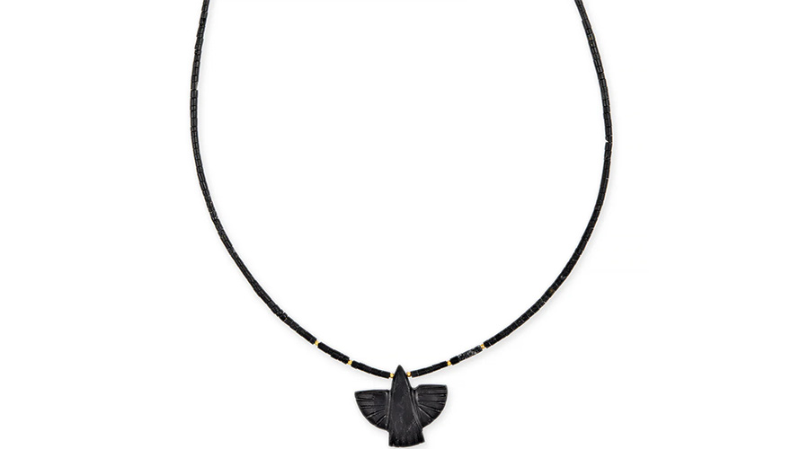 A black beaded necklace featuring a carved black pendant in the shape of a bird with outstretched wings, positioned at the center.