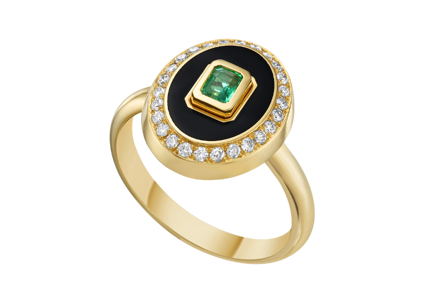 Lionheart gold ring A gold ring with an oval black onyx center, bordered by small white diamonds, featuring a rectangular green gemstone set in the middle.