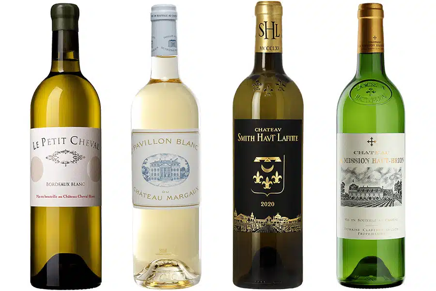 Four bottles of white wine stand side by side, each with distinct labels: Le Petit Cheval, Pavillon Blanc, Château Smith Haut Lafitte 2020, and Château La Mission Haut-Brion.