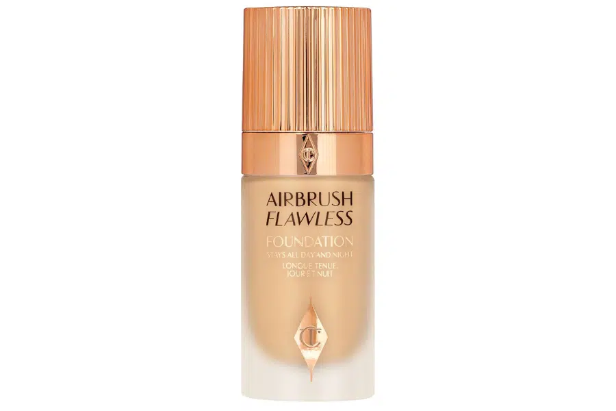 A bottle of Charlotte Tilbury Airbrush Flawless Foundation with a gold cap and frosted glass, featuring gold and black text on the label.