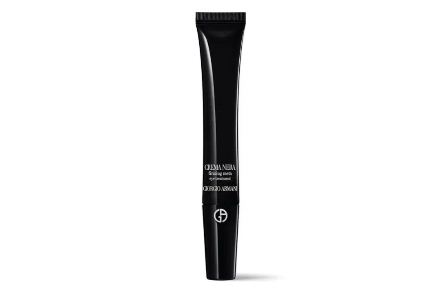A sleek black tube of Giorgio Armani Crema Nera Firming Eye Serum stands upright against a white background, featuring silver text and the brand’s logo near the base.