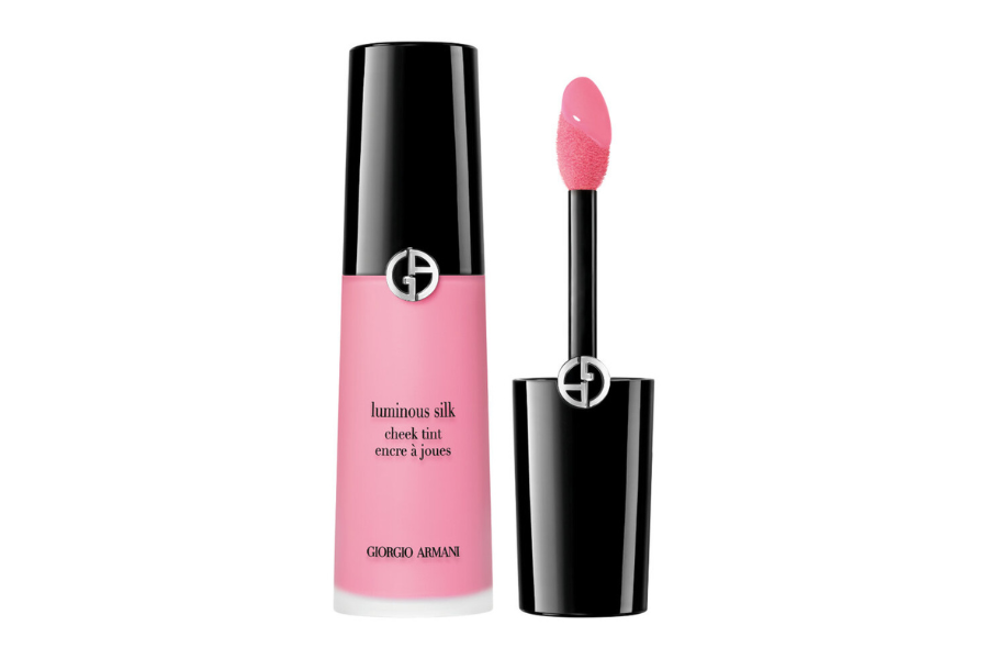 A bottle of Giorgio Armani Luminous Silk Cheek Tint in pink, with a black cap and applicator wand featuring a pink sponge tip, displayed against a white background.