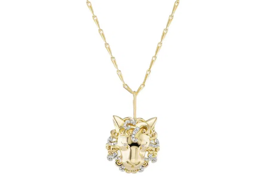 A gold necklace featuring a pendant shaped like a foxs head, adorned with small clear gemstones around the face, hanging from a delicate chain.
