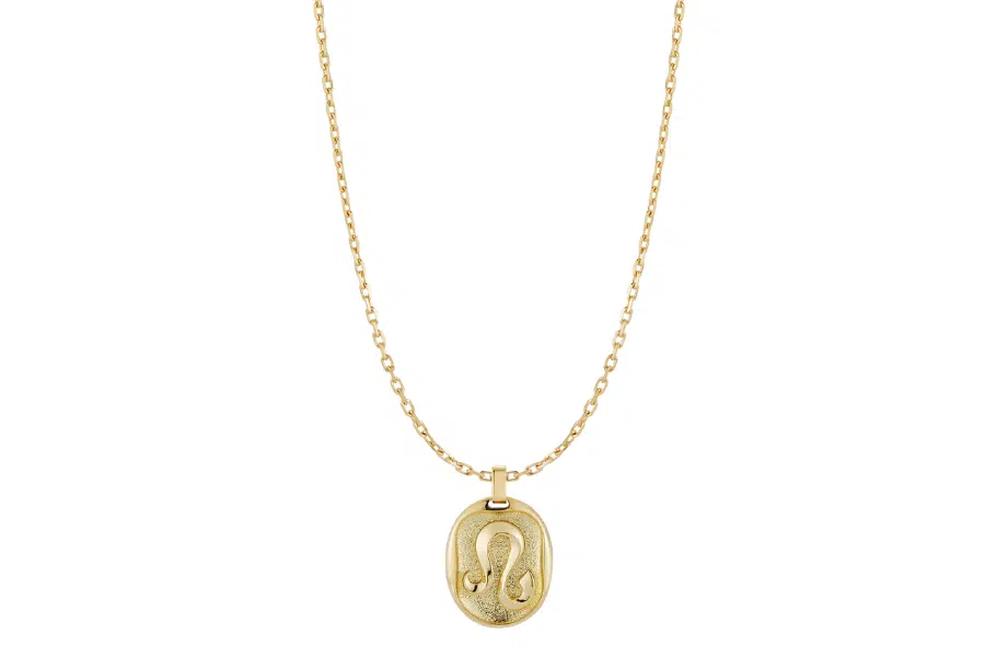 A gold chain necklace featuring an oval pendant engraved with the Leo zodiac symbol.