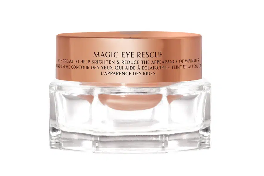A clear glass jar with a rose gold lid labeled Magic Eye Rescue, containing eye cream designed to brighten and reduce the appearance of wrinkles.