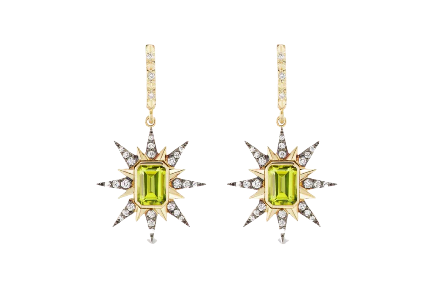 Dangling earrings with starburst designs, featuring rectangular green gemstones in the center and surrounded by small clear crystals, set in gold with diamond-encrusted hooks.