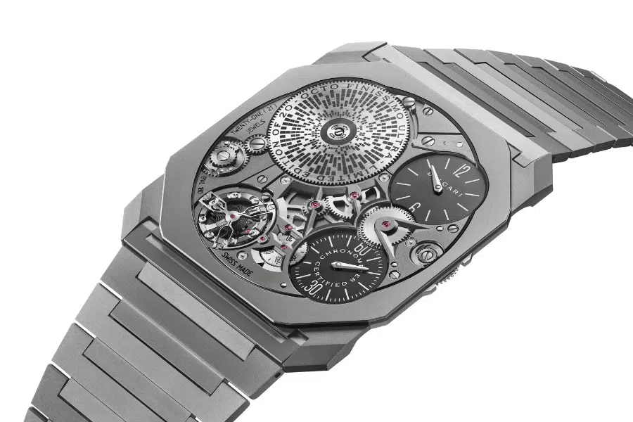 A luxury watch with a skeleton dial showcasing intricate gears and mechanisms. The watch has a silver metal bracelet and multiple smaller dials, revealing detailed engineering work.