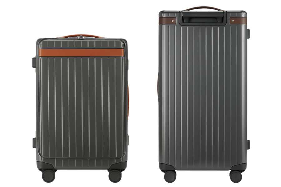 Two gray hard-shell suitcases with vertical ridges, brown accents, and four wheels each are shown standing upright. One suitcase is slightly smaller than the other.