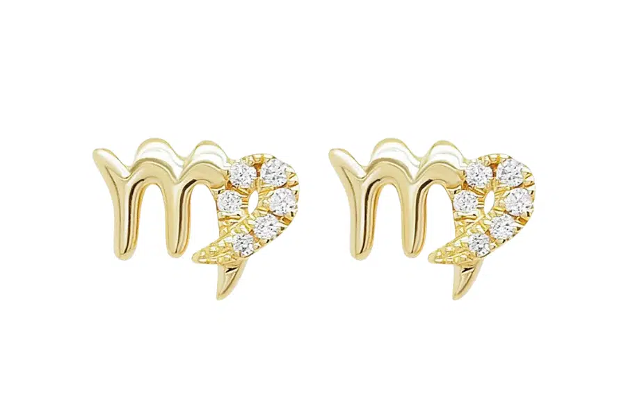 A pair of gold stud earrings shaped like the Virgo zodiac symbol, with one side decorated with small, sparkling white gemstones.