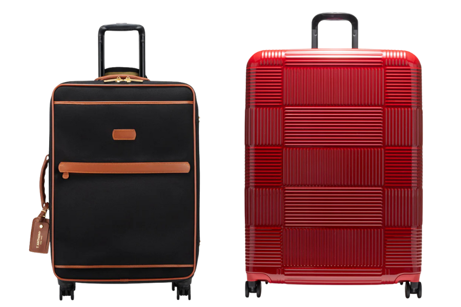 Two upright suitcases: one is black with brown trim and front pocket, the other is bright red with a textured, ribbed pattern; both have extended handles and four wheels.