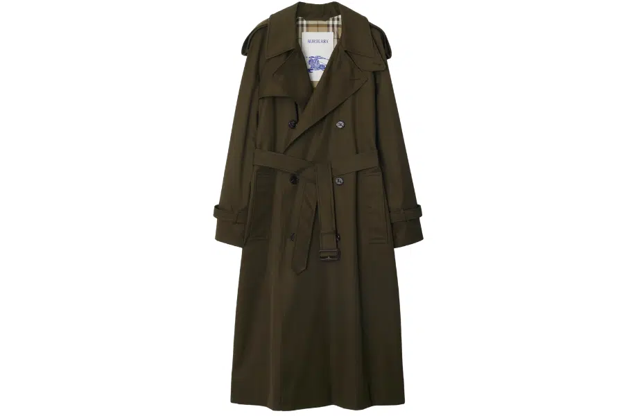 A long, dark green trench coat with a belt at the waist, double-breasted buttons, shoulder epaulets, and a plaid lining visible inside the collar.