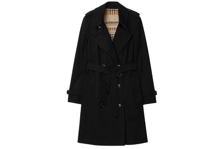 A black trench coat with a belted waist, double-breasted button front, and a tan plaid lining visible at the collar. The coat features shoulder epaulets and buttoned cuffs.