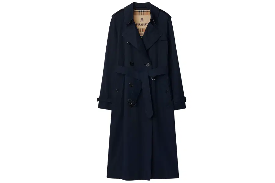 A long, dark navy blue trench coat with a belt at the waist, double-breasted buttons, and a beige plaid lining visible at the collar.