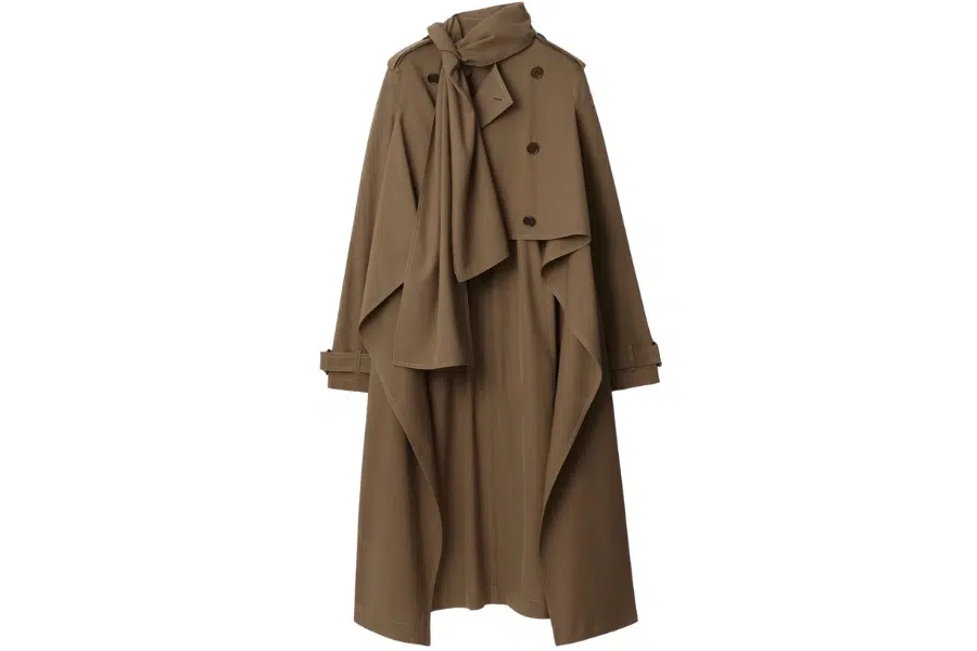 A long brown trench coat with a wide lapel, double-breasted buttons, belted cuffs, and a matching scarf draped around the neck, displayed on a plain white background.