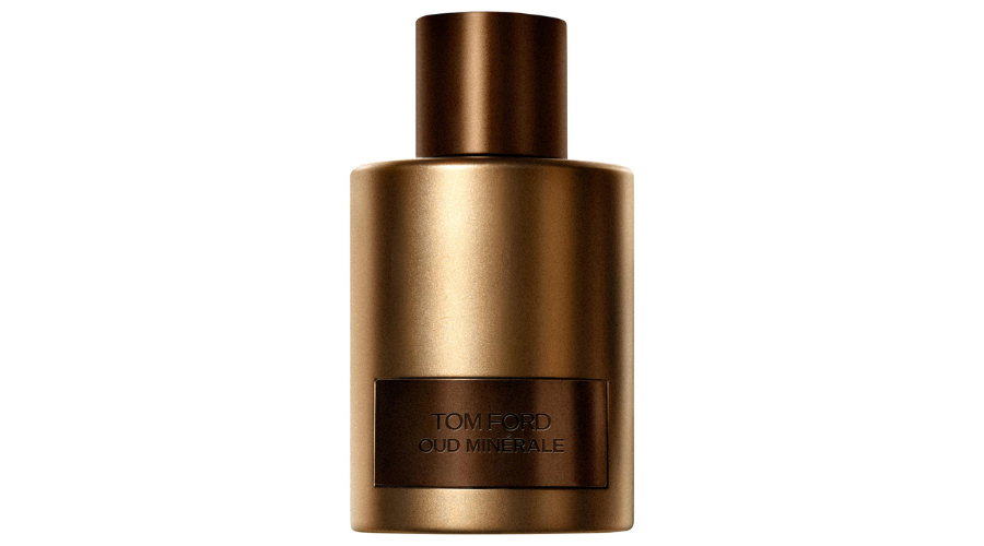 A metallic bronze bottle of Tom Ford Oud Minerale perfume, featuring a cylindrical shape and a matching cap, with the label embossed on the front.