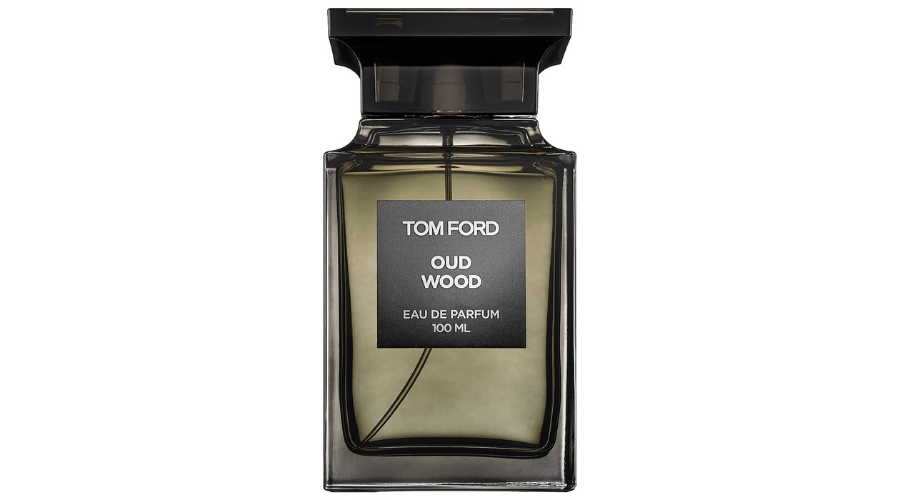 A sleek, rectangular dark glass bottle of Tom Ford Oud Wood Eau de Parfum, 100 ml, with a black cap and a label displaying the brand name and fragrance details on the front.