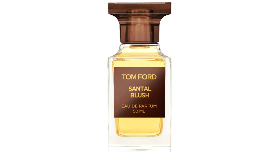 A clear glass bottle of Tom Ford Santal Blush Eau de Parfum, 50 ml, with amber-colored liquid and a brown, rectangular cap. The brown label displays the brand and product name in gold text.