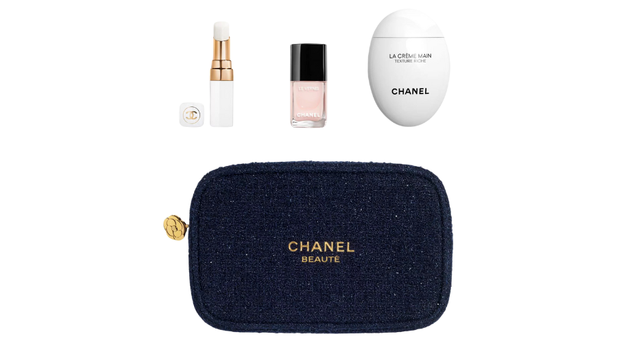 A Chanel beauty set including a lipstick, pale pink nail polish, white hand cream, and a navy zippered pouch with gold Chanel Beauté text and logo. The items are arranged above the pouch.