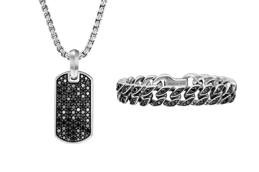 A silver dog tag necklace with a black gemstone-encrusted pendant beside a matching silver chain-link ring, both featuring black gemstone accents, displayed on a white background.