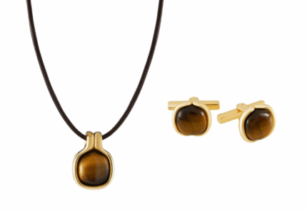 A matching jewelry set with a tiger’s eye pendant on a black cord necklace and a pair of gold-framed tiger’s eye cufflinks on a white background.