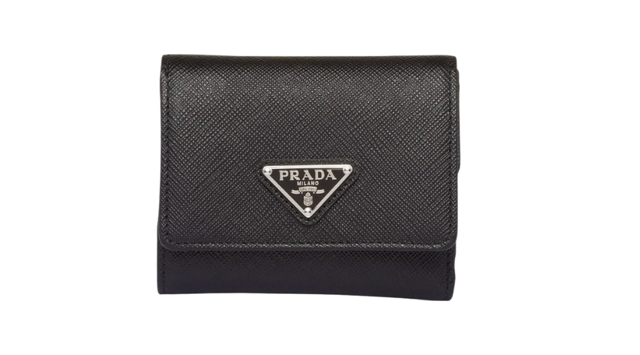 A black Prada wallet with a textured finish, featuring a triangular silver Prada Milano logo plate on the front. The wallet is closed and shown against a white background.