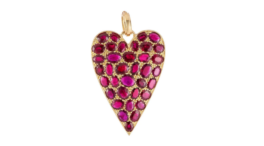 A gold heart-shaped pendant adorned with multiple oval and round red gemstones, arranged closely together, on a plain white background.