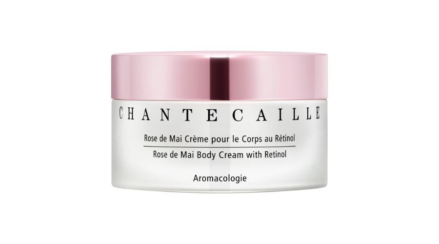 A white jar with a metallic pink lid labeled Chantecaille Rose de Mai Body Cream with Retinol and Aromacologie on the front. The text is in both French and English.