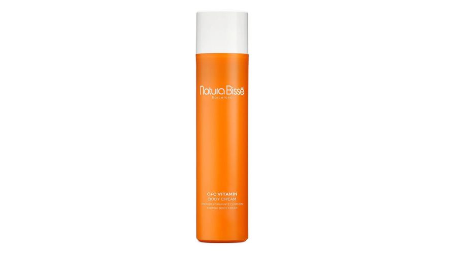 Tall orange bottle with a white cap, labeled Natura Bissé C+C Vitamin Body Cream in white text. The design is sleek and minimalistic, set against a plain white background.