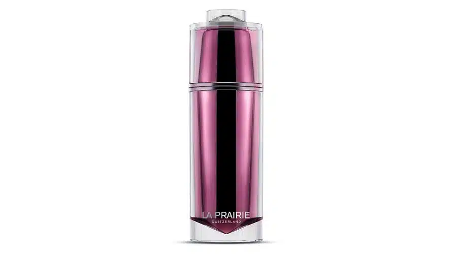 A tall, sleek, metallic pink bottle with a clear cap, labeled La Prairie Switzerland at the bottom, set against a white background.