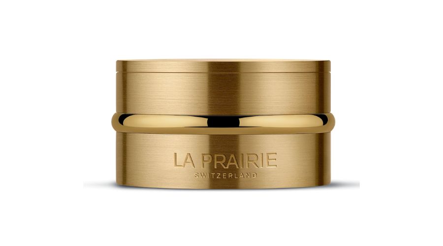 A gold cylindrical jar with LA PRAIRIE SWITZERLAND engraved on the front, set against a white background.