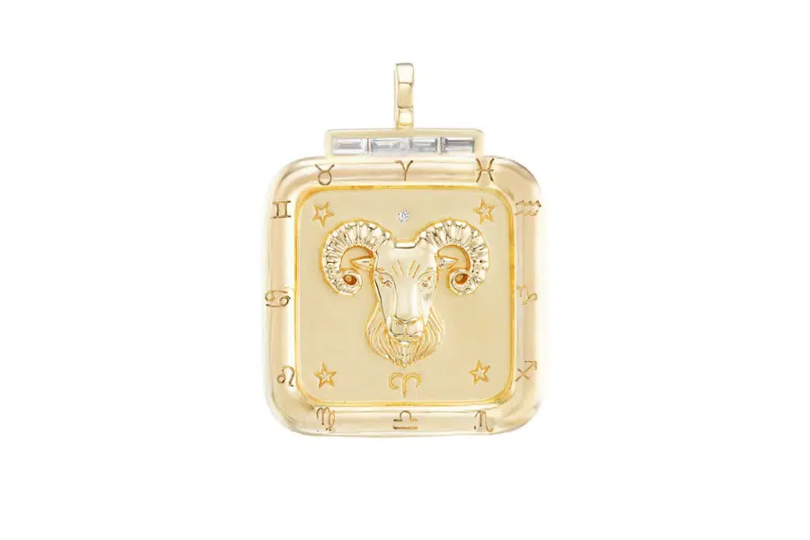 A square gold pendant featuring a ram’s head in the center, surrounded by zodiac symbols and small stars, with a small diamond above the ram. The pendant has a bail at the top for attaching to a chain.