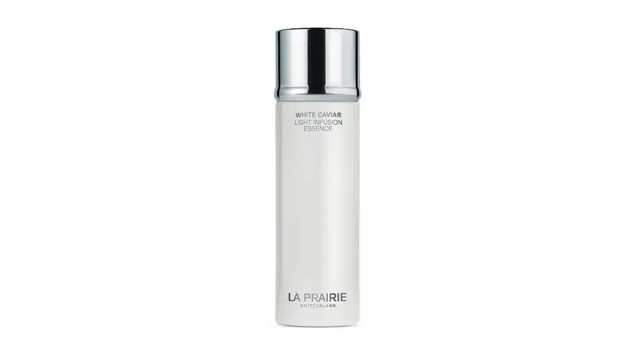 A sleek white bottle with a shiny silver cap labeled White Caviar Light Infusion Essence by La Prairie, Switzerland, is shown against a plain white background.